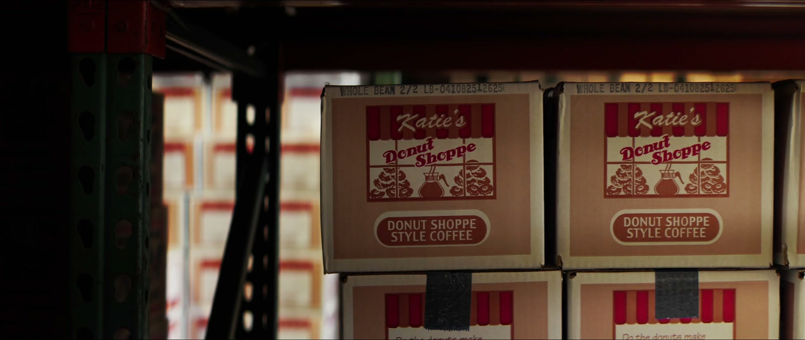 Cases of Katie's Donut Shoppe coffee stacked on warehouse shelves