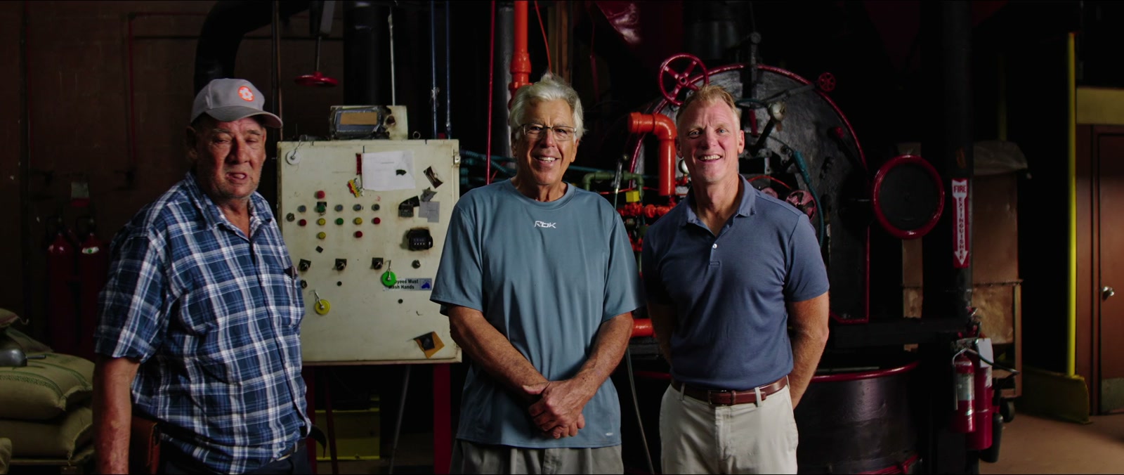 Three men standing in front of a coffee roaster