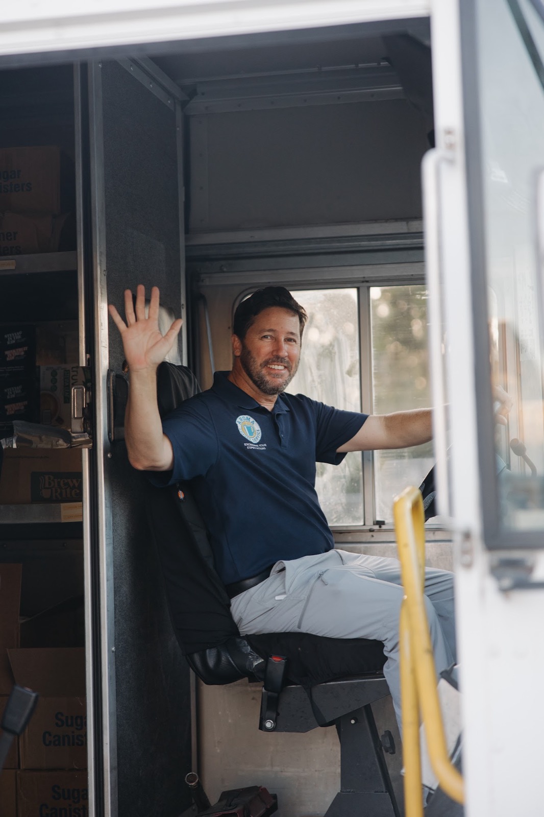 Aroma delivery driver waving from the seat of his truck